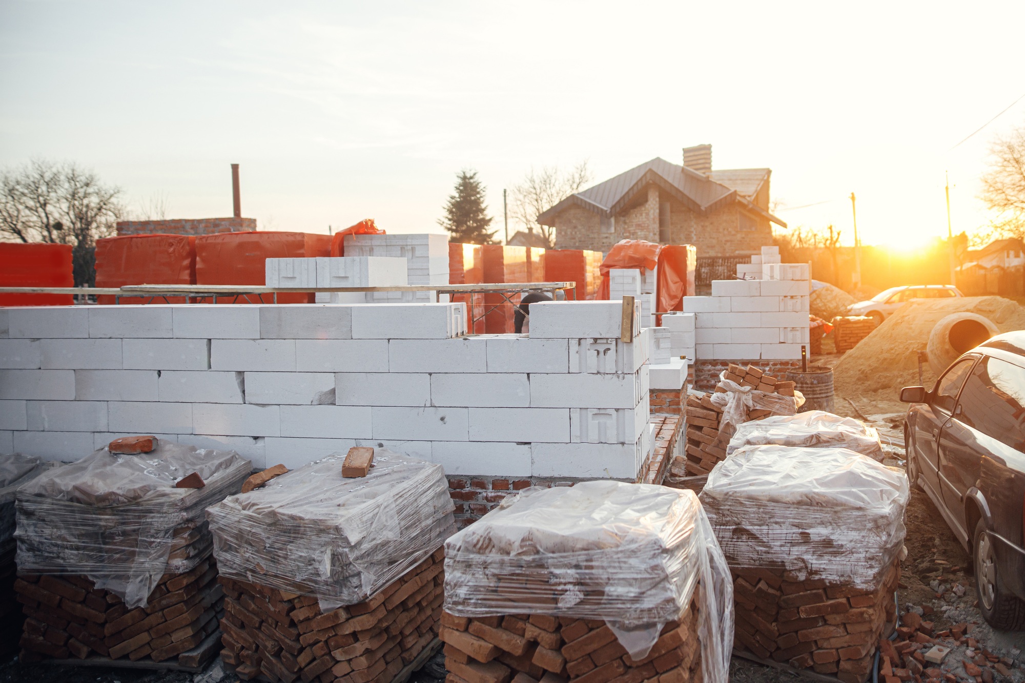 Aerated blocks on concrete foundation and bricks in sunset. Building materials at construction site